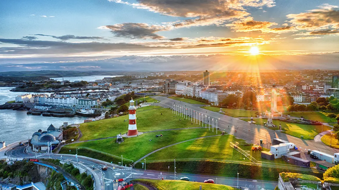 Aerial view of Plymouth coast with lighthouse and dramatic sunrise