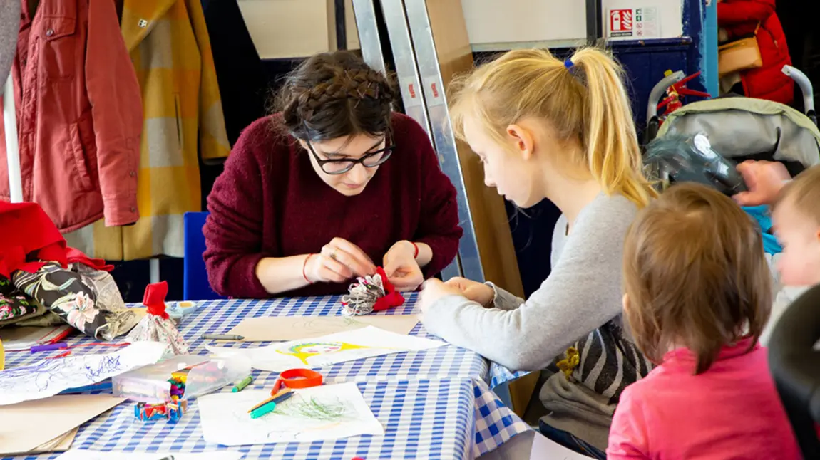 Stories of Eastern European community live on, thanks to emergency funding Woman making crafts with children