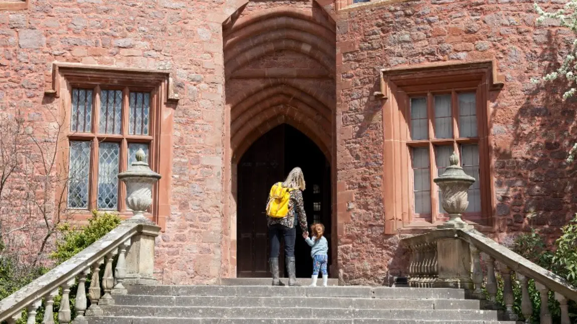 Adult and child entering historic building.