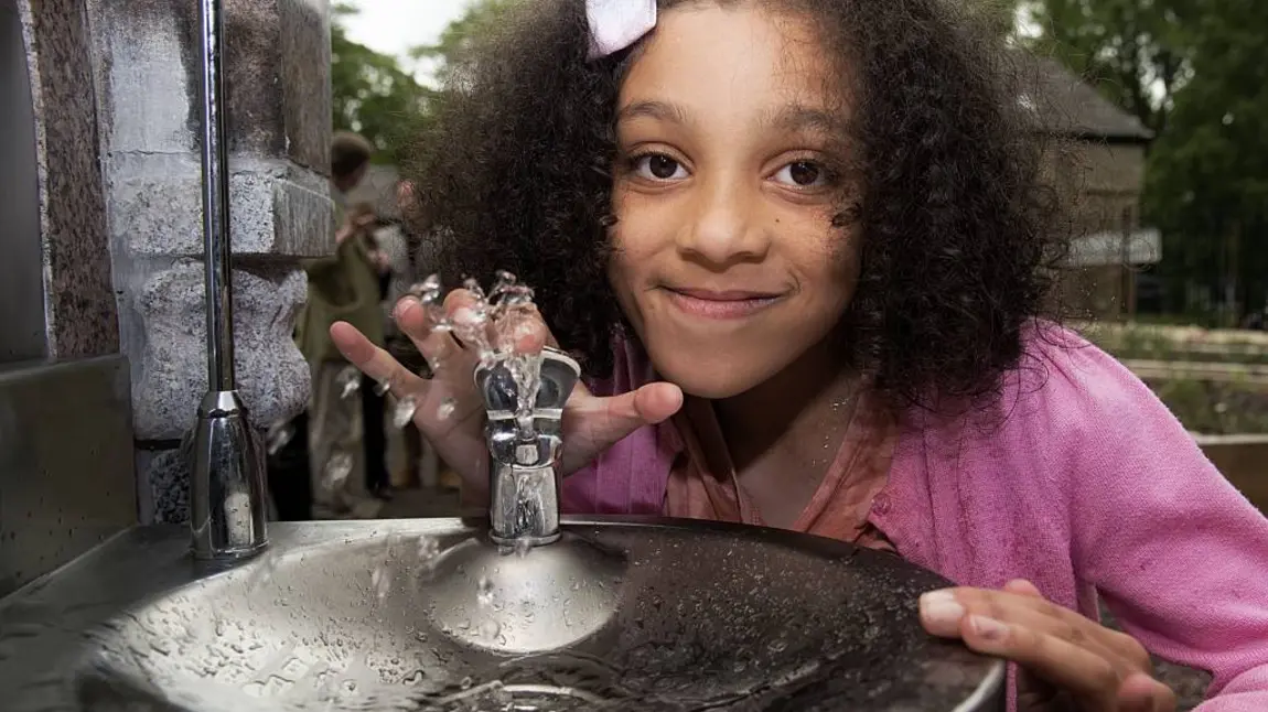 Girl using drinking fountain 