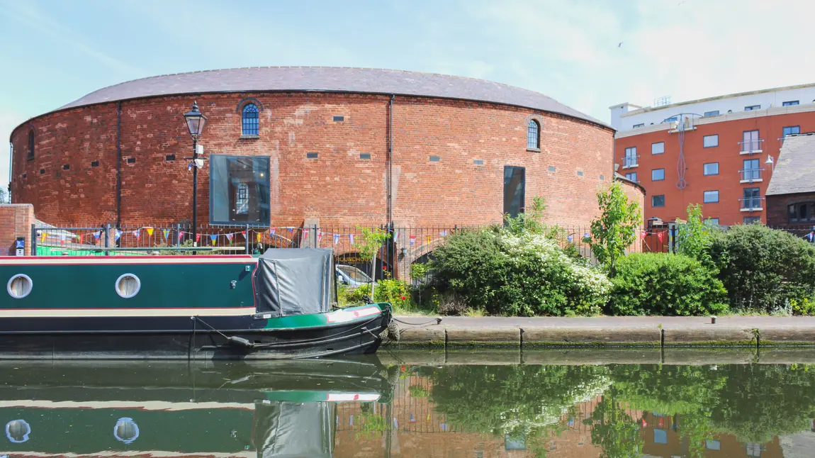 Round building with canal in foreground