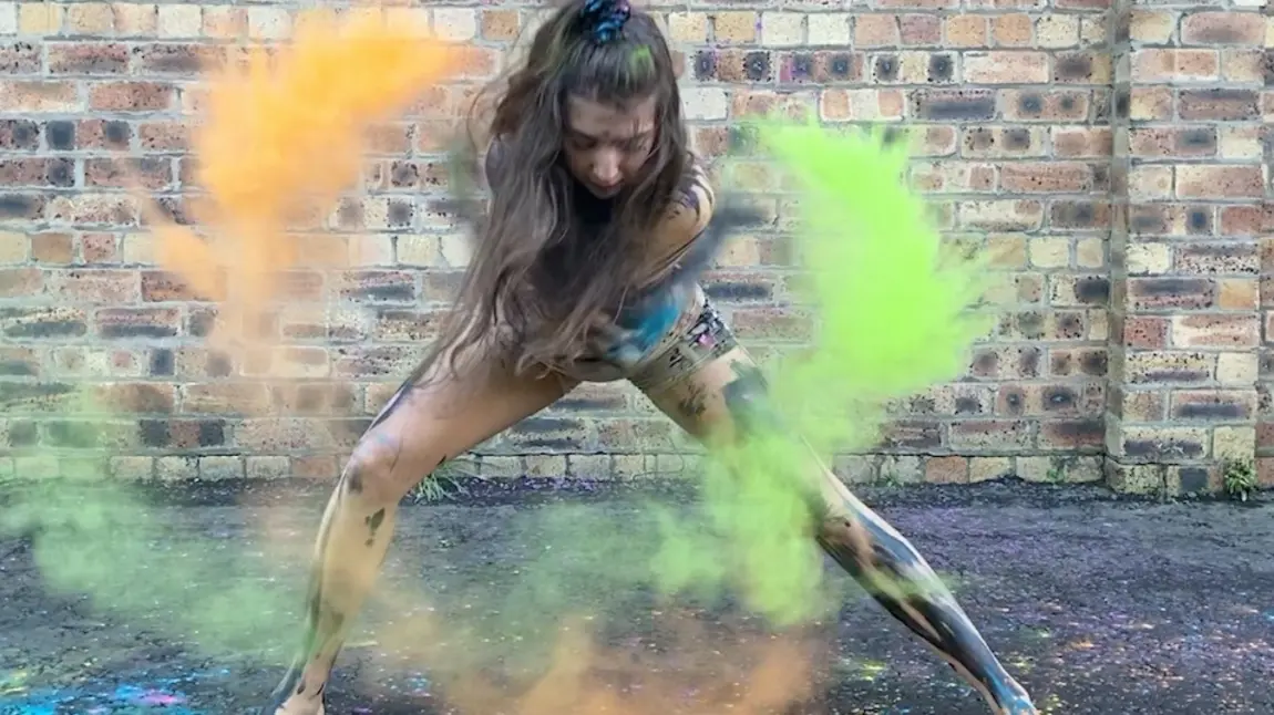 A young Shaper/Caper dancer from Dundee performs with coloured, powdered paint