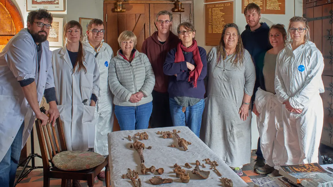 Group stand round skeletal remains