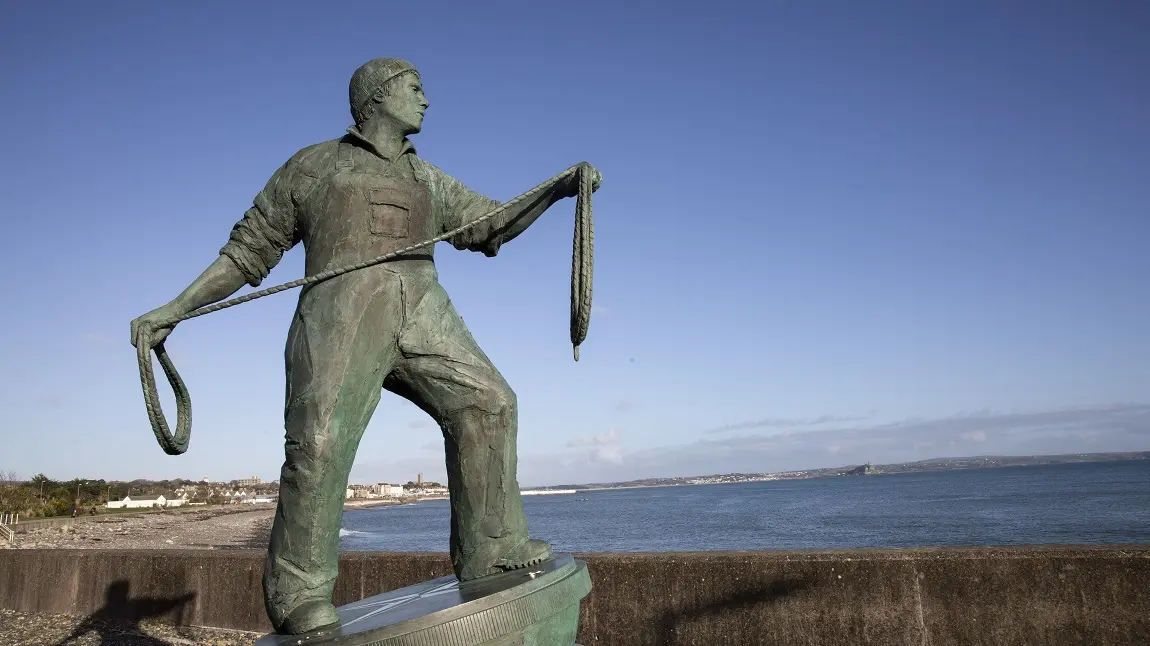 Sculpture of a fisherman holding a rope and looking out to sea