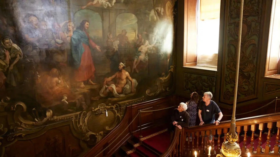 Visitors stand on the Hogarth Stair and look up at The Pool of Bethesda painting