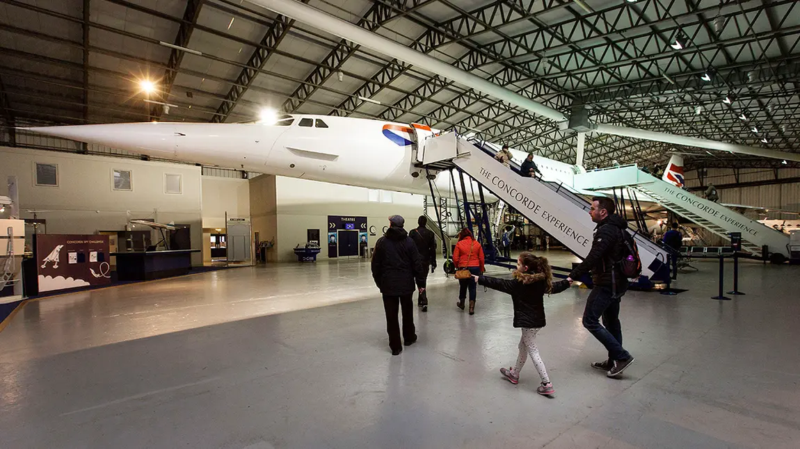 People approaching aeroplane in hangar 