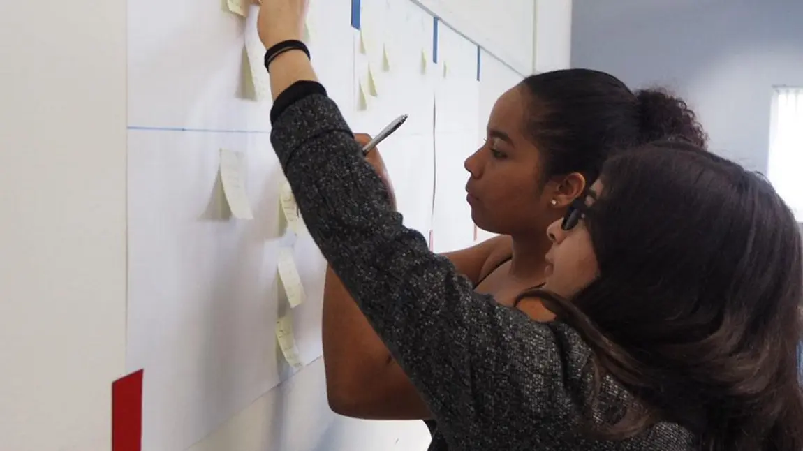 Two young people observing a notice board