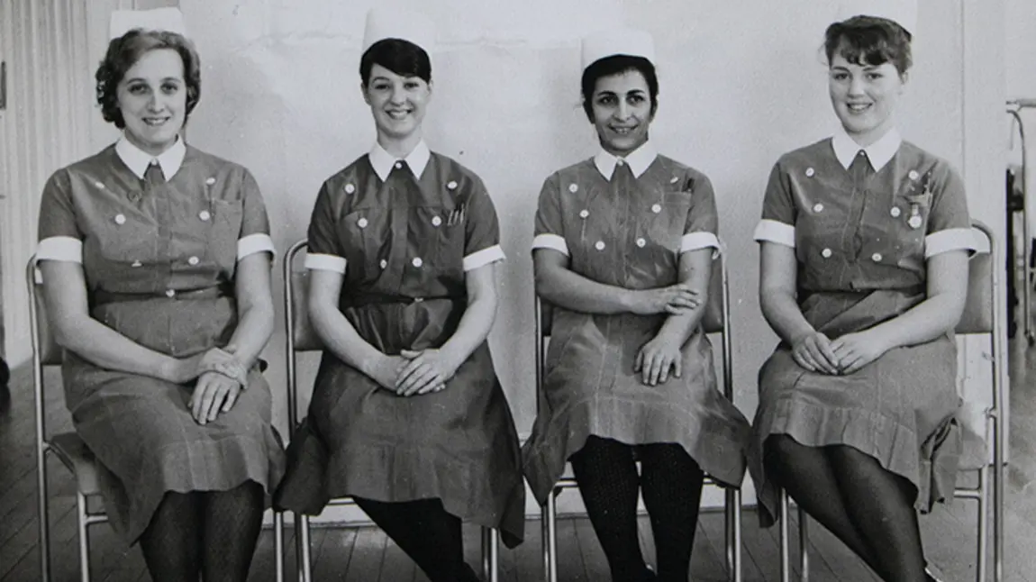 A black and white photograph of four nurses in uniform.
