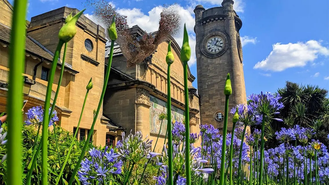 The Horniman Museum featuring a clock tower stands tall behind greenery