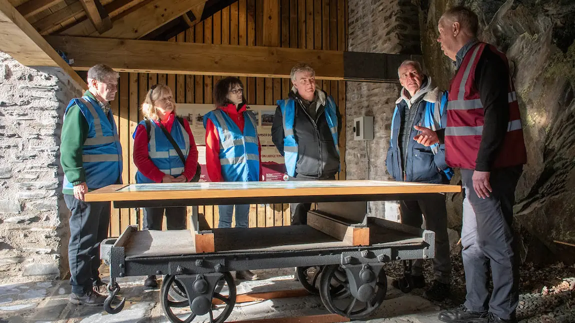 boston-lodge-tour_1.jpg A group of people in high-vis standing around a table converted from an old railway wagon