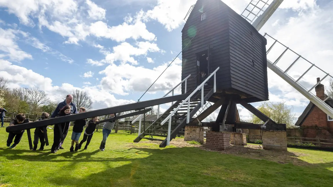 A group of people including children turn Bourn Windmill