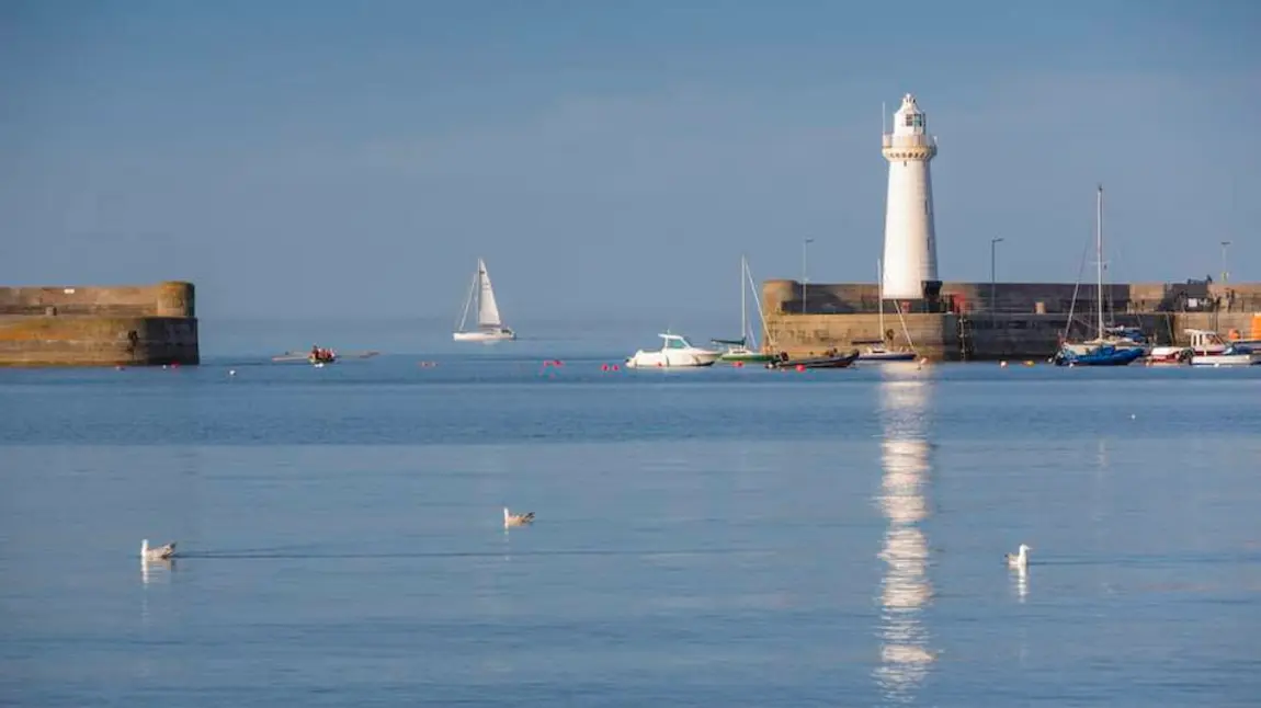 Donaghadee Harbour with a lighthouse and a number of boats.