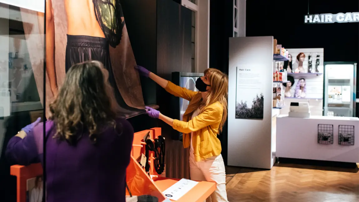 Installing Hair: Untold Stories at the Horniman Museum Two people install an artwork in an exhibition