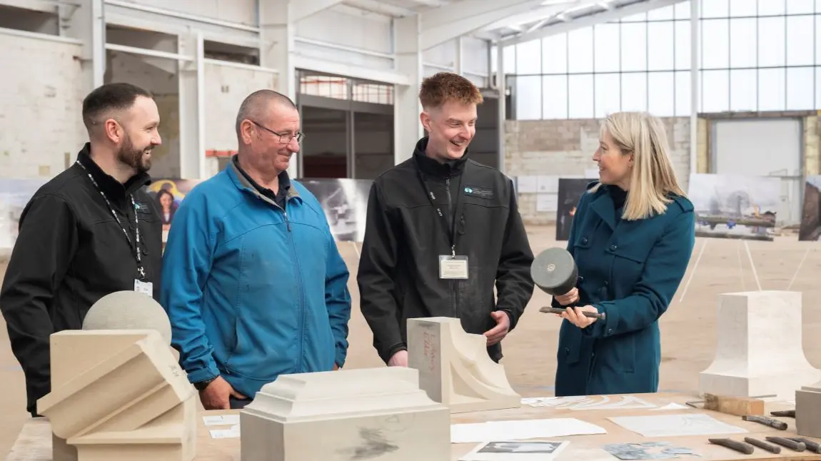 Mae Scottish Canals wedi derbyn £3.7m i greu canolfan sgiliau newydd ar lannau Camlas Forth a Clyde yn Falkirk. Three stonemasons talk to a member of the Heritage Fund team about a selection of tools and craft items from their workshop.