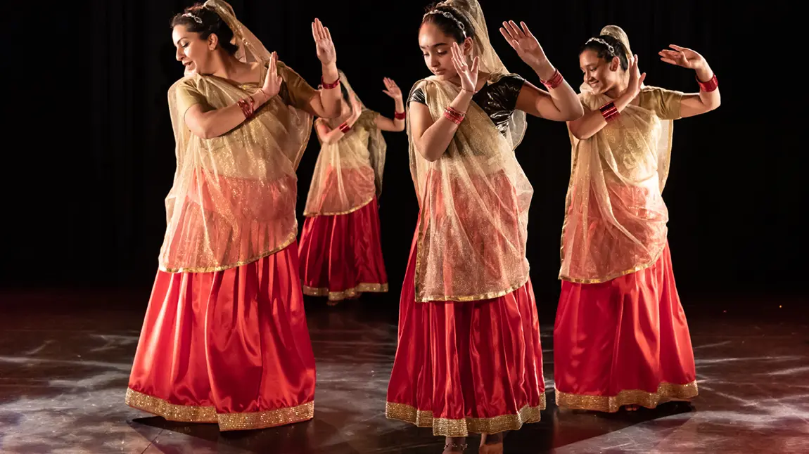 A group of women in traditional dress doing an Indian dance