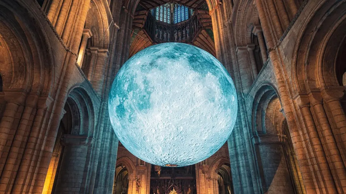 A large artwork of the moon hanging in Ely Cathedral