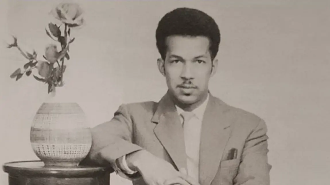 Black and white photograph of man sitting down