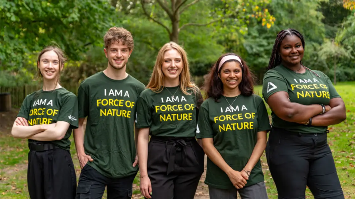New to Nature trainees Pum person ifanc yn sefyll ochr yn ochr yn gwisgo crysau-t â 'we are a force of nature' arnynt
