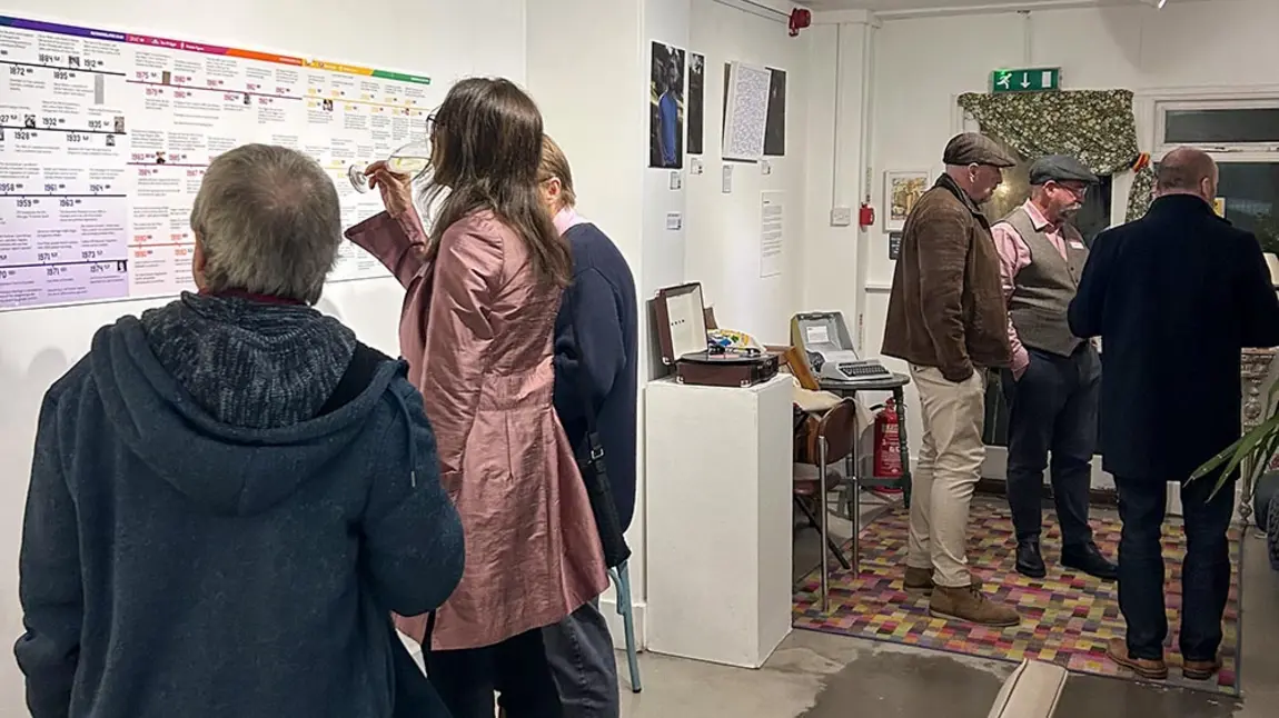 People look at an exhibition of LGBTQ+ people's stories