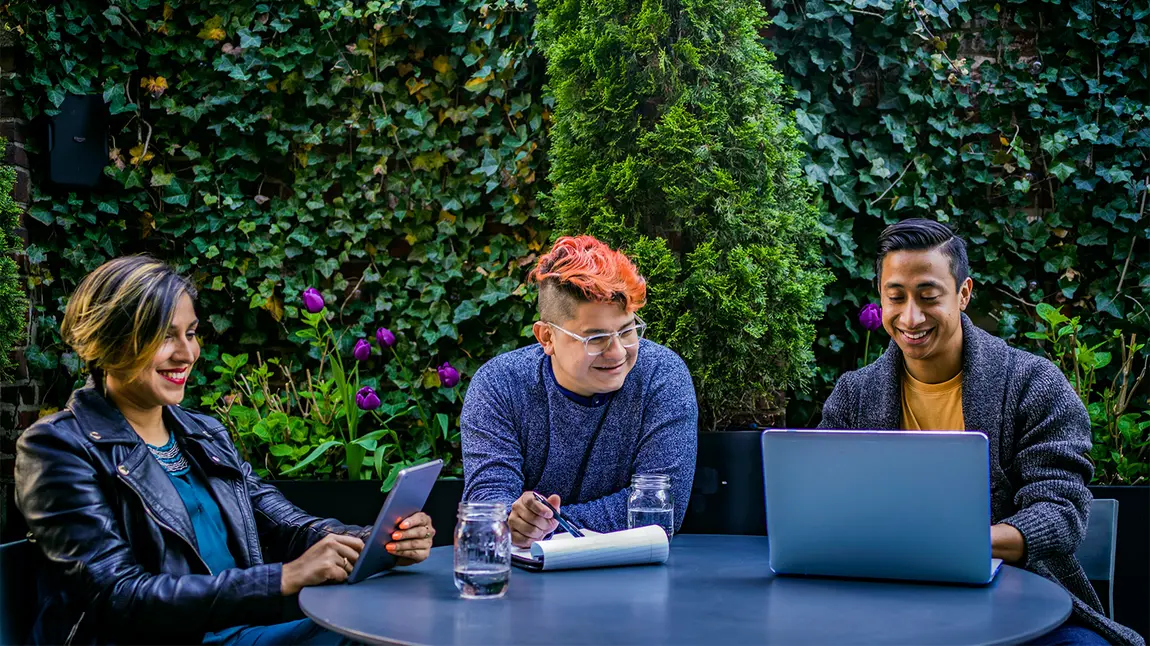 Three people using laptop and tablet