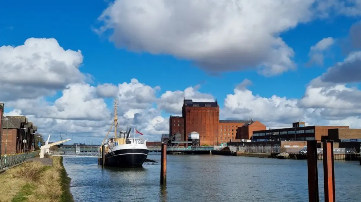 a large ship docked on the river in Grimsby