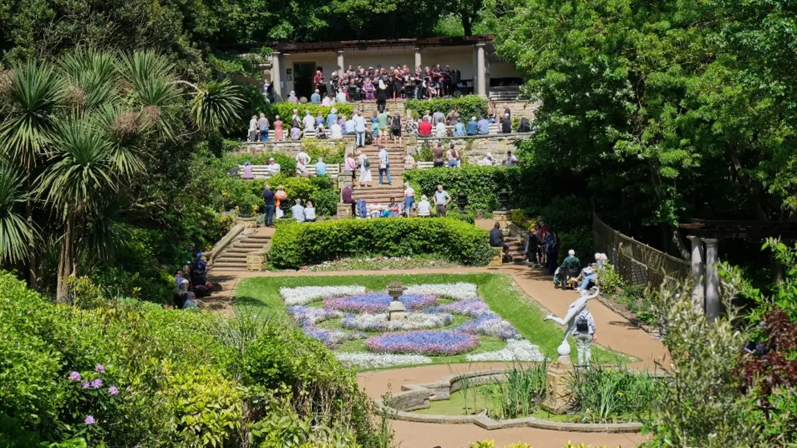 The Scarborough South Cliff gardens on a sunny day, with visitors enjoying an opening event performance