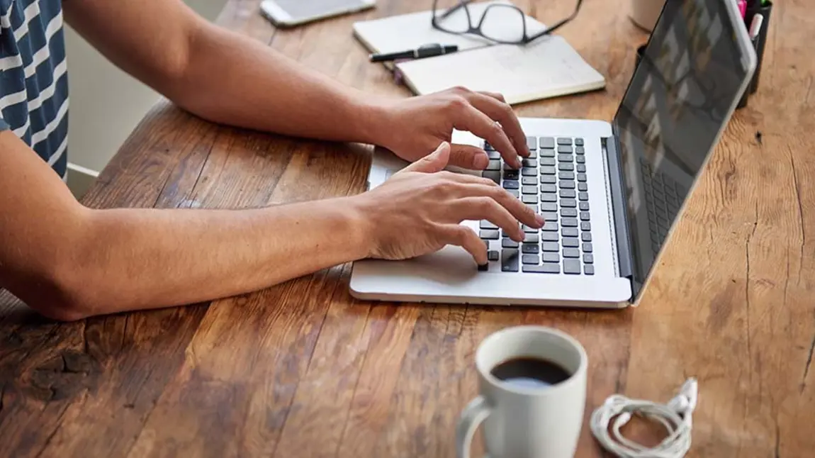 Man typing on laptop on desk