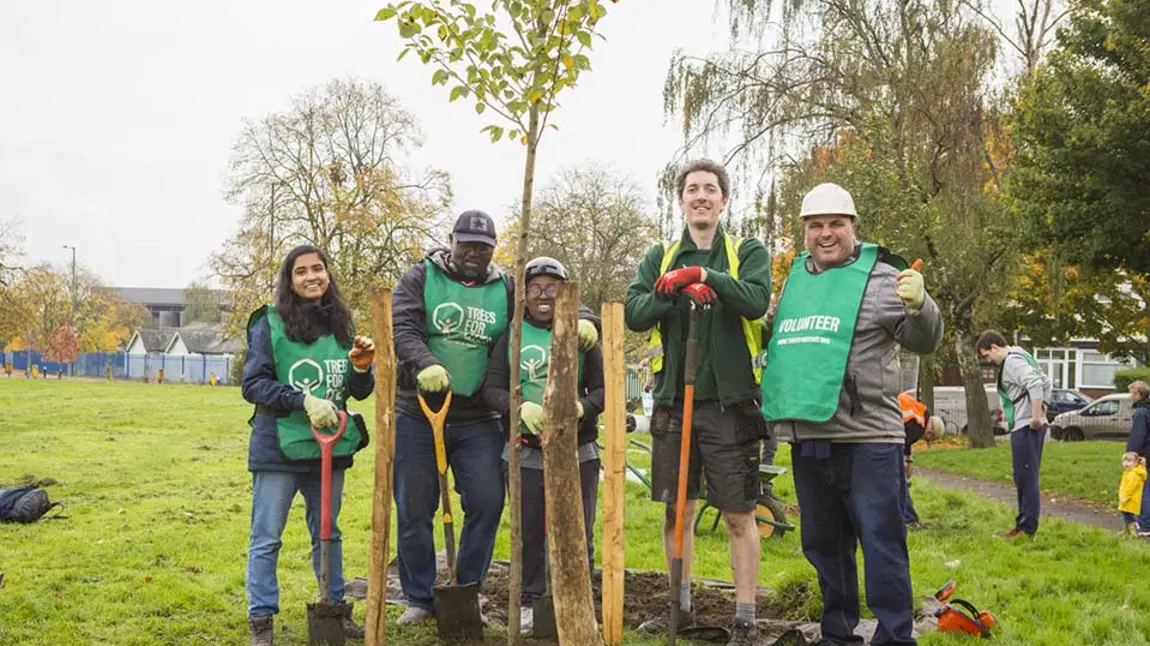 Trees for Cities volunteers at a tree-planting session A group of Trees for Cities volunteers pose for the camera during a tree-planting session