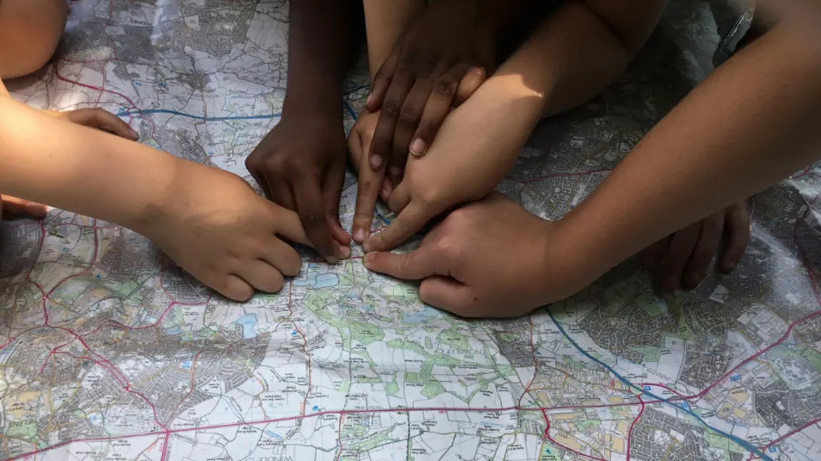 Photograph of hands pointing at a map