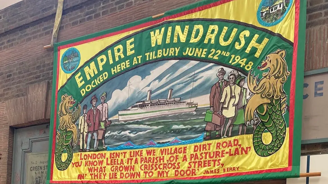 A colourful banner commemorating the landing of the Empire Windrush, saying 'Docked here at Tilbury, June 22nd 1948'
