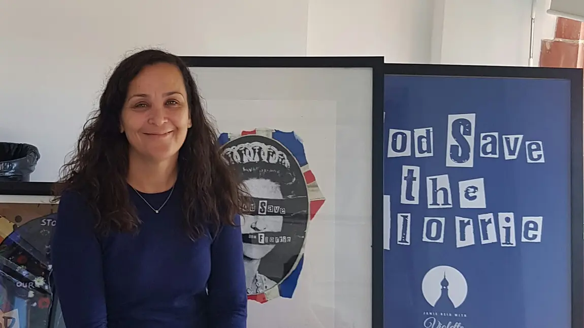 Anne Lundon, Chief Executive of the Florrie, smiles in front of campaign artworks