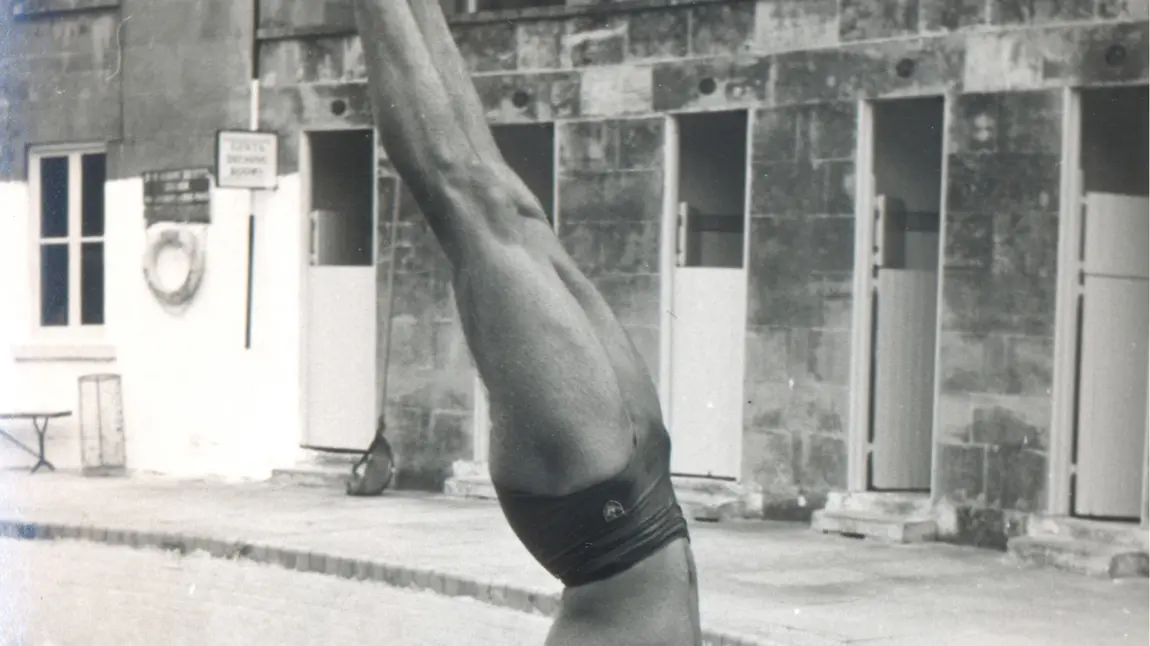 UK’s oldest open-air pools to be restored to their former glory Man doing a handstand by a swimming pool