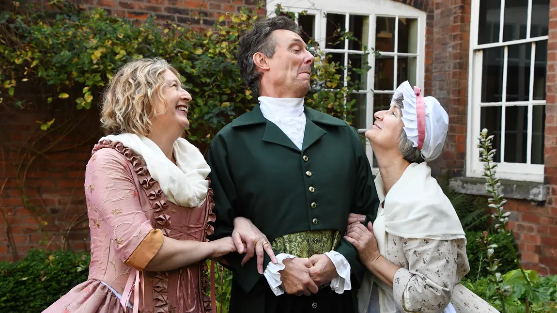 Three people in 18th-century costume