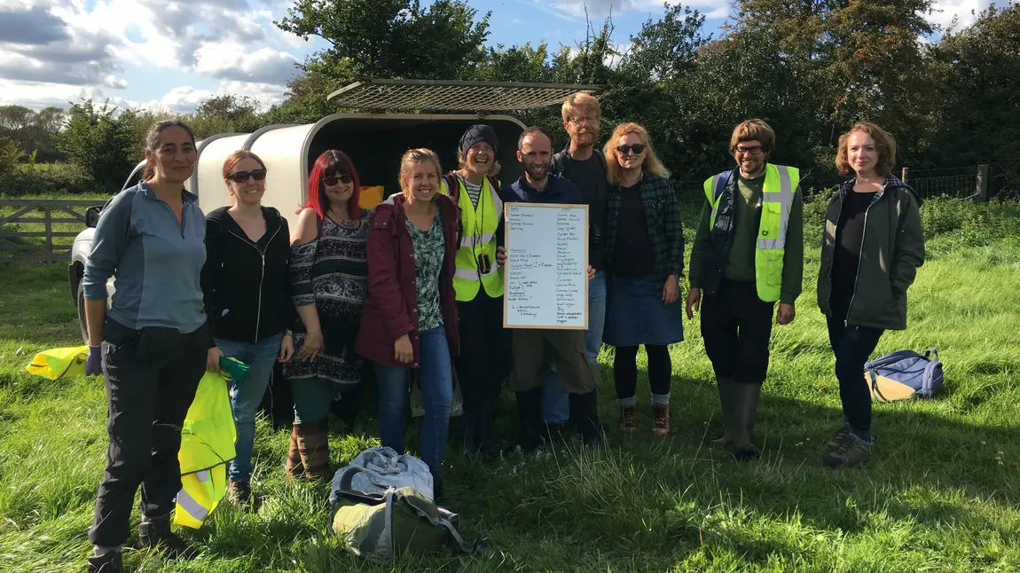 People stand in a field with a sign