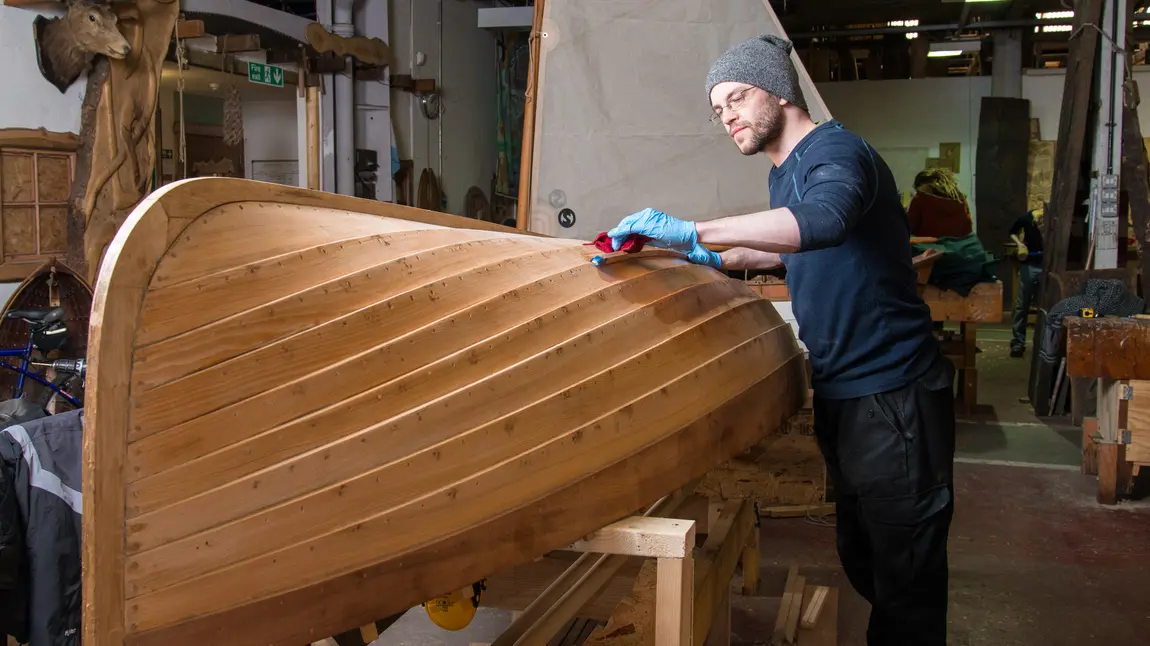 A man fixes a boat A man fixes a boat