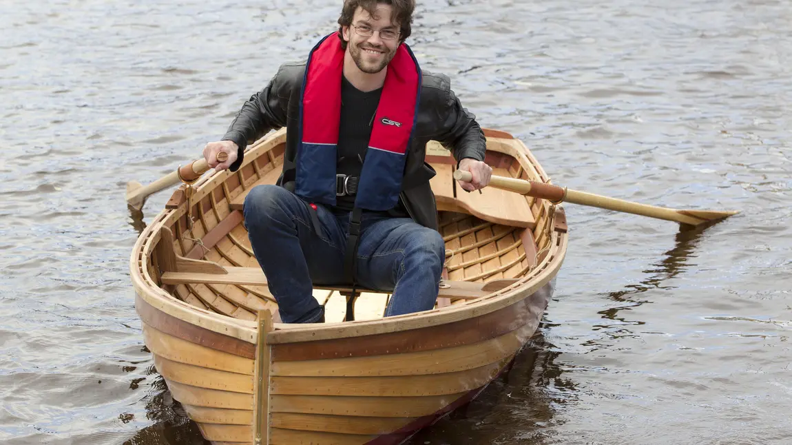 A man in a dinghy on the River Clyde