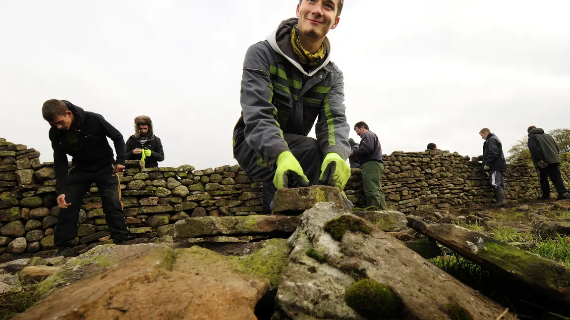 A trainee working on a dry stone wall