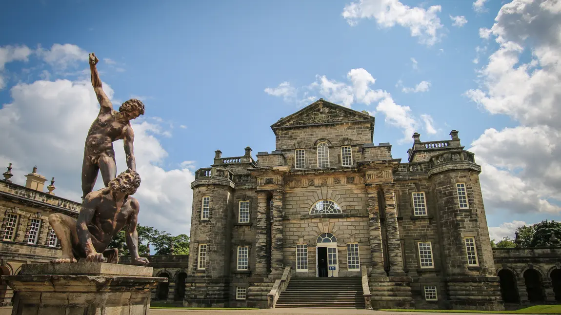 Seaton Delaval Hall, a baroque manor house flanked by elaborate stone statues
