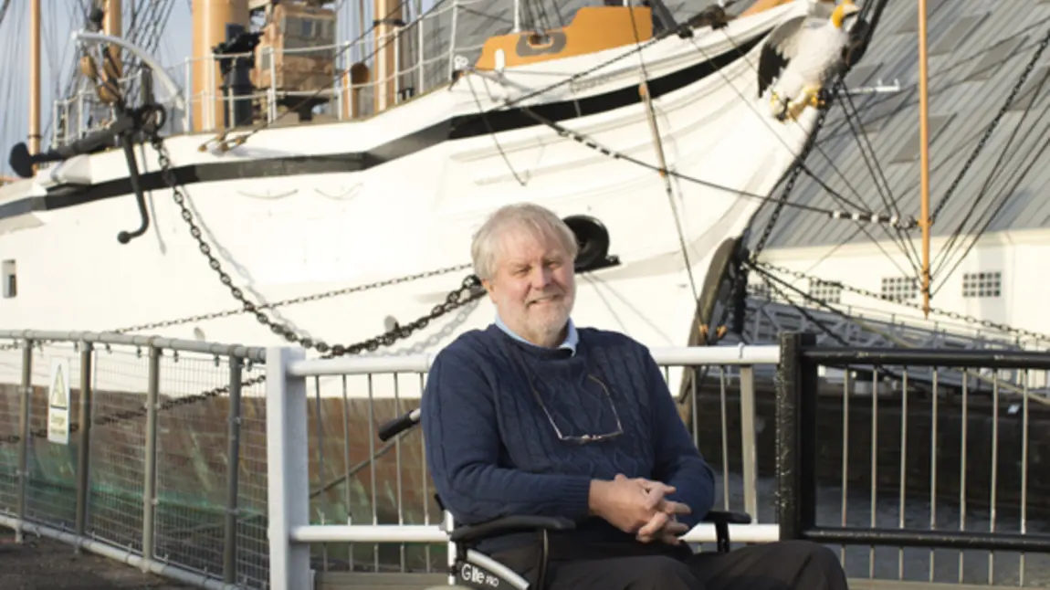Tony at the Historic Dockyard Man in wheelchair in front of a ship