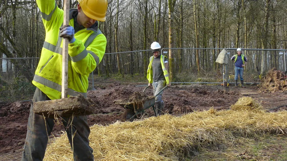 A volunteer lays foundations
