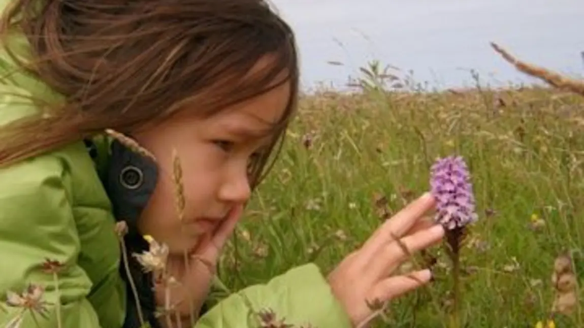 Girl looking at an orchid