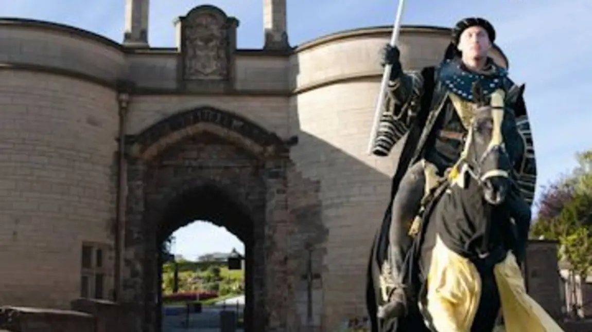 A horseman in costume rides out of Nottingham Castle