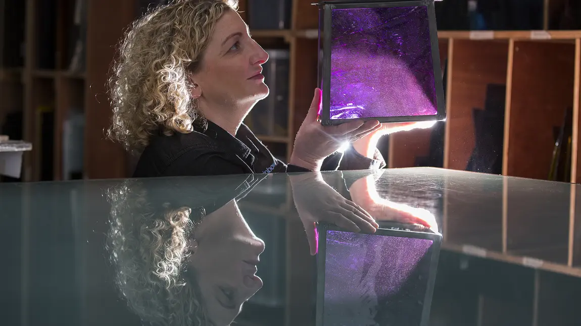 Moira Malcolm, Director of Rainbow Glass Studio, holds a replica glass lamp created for the Oak Room in V&A Dundee