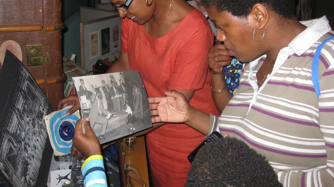 Living Legends V&A. People inspecting images from the archive