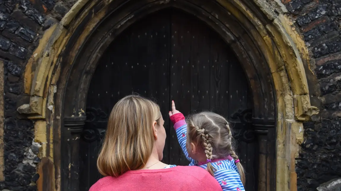 Mother and little girl look at St John Maddermarket Church, Norwich