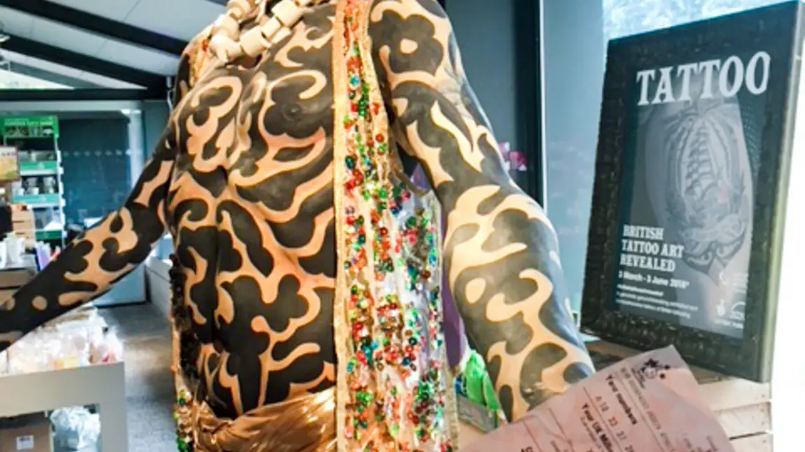 Free tattoo exhibition for National Lottery players Omi, part of the exhibition, with National Lottery ticket