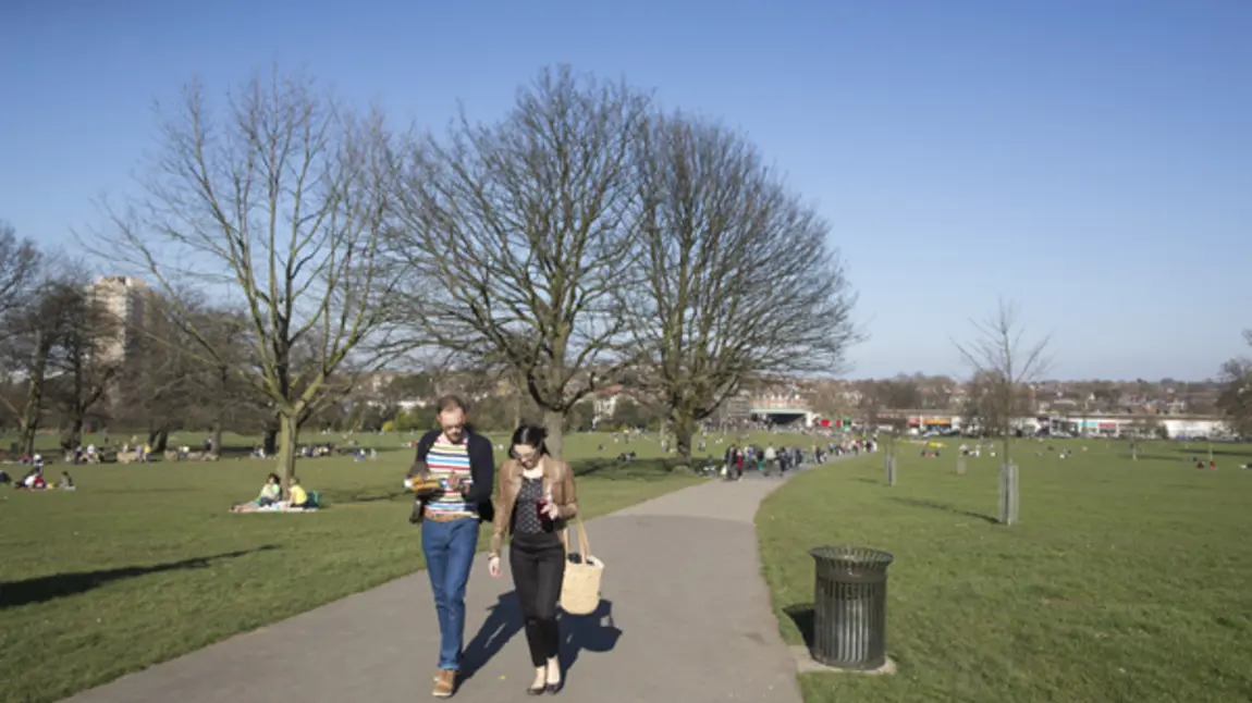A man and woman walk in Brockwell Park A man and woman walk in Brockwell Park