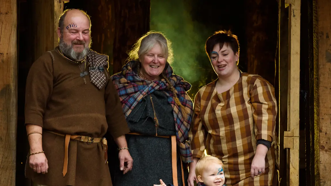 Record Numbers Delve into Heritage to Celebrate Scotland’s Special Year A family group in Iron Age dress in the doorway of the round House