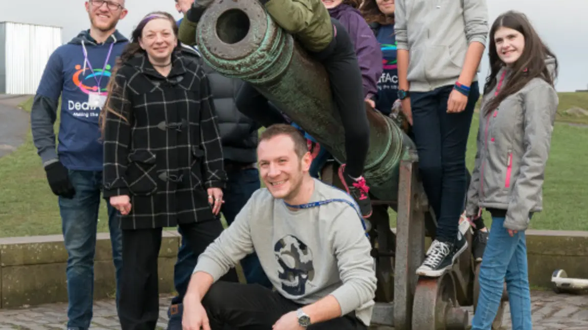 Participants gather around a cannon
