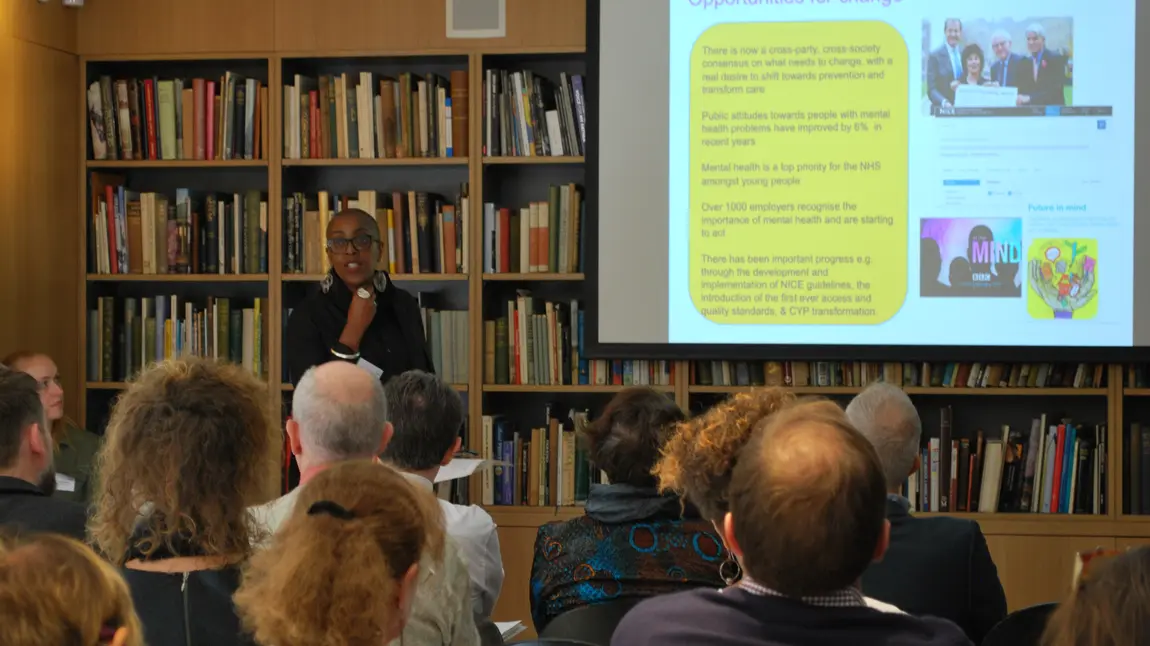 A speaker in front of bookshelves